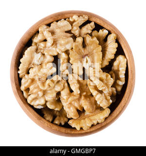 Walnut kernel halfs in a wooden bowl on white background. Brown dried seeds of common walnuts, Juglans regia. Edible, organic. Stock Photo