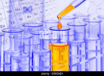 yellow drop of chemical liquid is falling in a test tube while an experiment Stock Photo