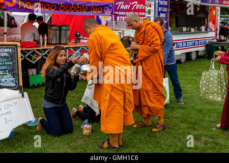Thai People Offer Food To Two Monks At The Brighton Thai Festival, Preston Park, Brighton, Sussex, UK Stock Photo