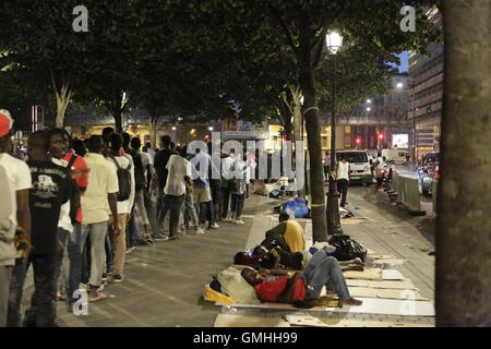 Paris, Italy. 25th Aug, 2016. Refugees are queueing up to receive their evening meal. Hundreds of refugees are sleeping rough in the streets around the Stalingrad Metro station in Paris. They are always under the thread of being moved by French police, as happens on a regular basis. Some wait for their asylum request being approved, others are on their way to the camp in Calais. © Michael Debets/Pacific Press/Alamy Live News Stock Photo