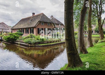 Giethoorn in The Netherlands is known for its bridges, waterways, thatched cottages  and punters and is also known as Dutch Venice Stock Photo