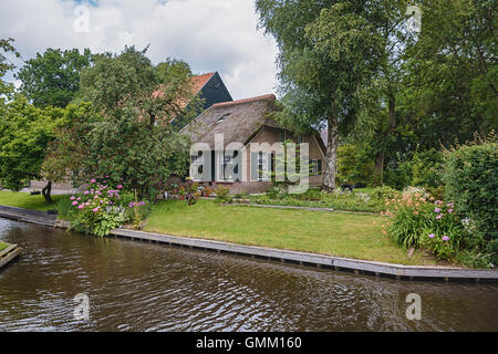 Giethoorn in The Netherlands is known for its bridges, waterways, thatched cottages  and punters and is also known as Dutch Venice Stock Photo