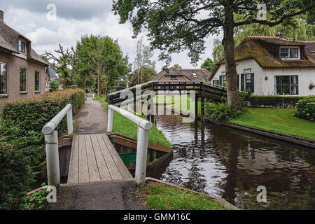 Giethoorn in The Netherlands is known for its bridges, waterways, thatched cottages  and punters and is also known as Dutch Venice Stock Photo