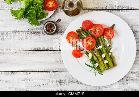 Warm salad of roasted asparagus, feta cheese and tomatoes. Top view Stock Photo