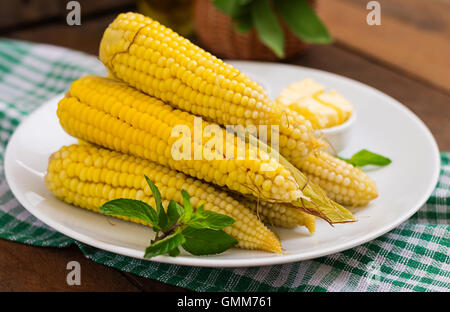 Boiled corn with salt and butter on a white plate Stock Photo