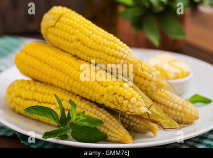 Boiled corn with salt and butter on a white plate Stock Photo