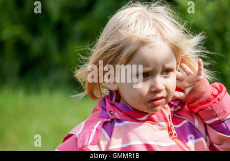 Sad little girl outside in the Garden Stock Photo