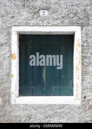 Close-up detail shot of old weathered square wooden window and concrete wall Stock Photo