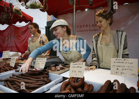 Polish girls selling Polish sausage in Borough Market, London's oldest food market situated in the borough of Southwark. Stock Photo
