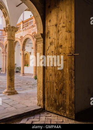 Castle La Calahorra steel reinforced, heavy door and through the doorway to the Italian Renaissance courtyard arches. Stock Photo