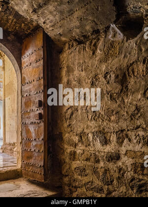 Castle La Calahorra steel reinforced, heavy door and through the doorway to the Italian Renaissance courtyard arches. Stock Photo