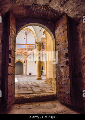 Castle La Calahorra steel reinforced, heavy door and through the doorway to the Italian Renaissance courtyard arches. Stock Photo