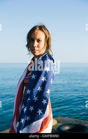 Young woman with wet hair in american flag on pier Stock Photo