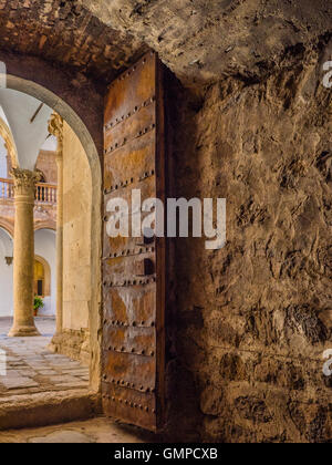 Castle La Calahorra steel reinforced, heavy door and through the doorway to the Italian Renaissance courtyard arches. Stock Photo