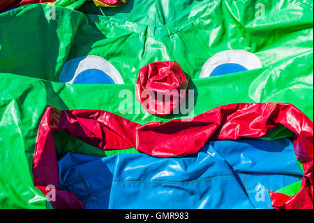 A deflated bouncy castle reveals a sad crumpled face (Portsmouth, England) Stock Photo