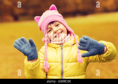 happy beautiful little girl waving hands outdoors Stock Photo