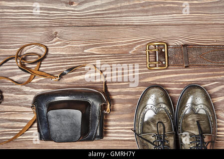 Green leather shoes and retro still camera on wooden background Stock Photo
