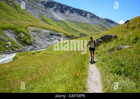Woman touching the grass in the Valley Ferrand, Alps, Oisans, France, Europe. Stock Photo