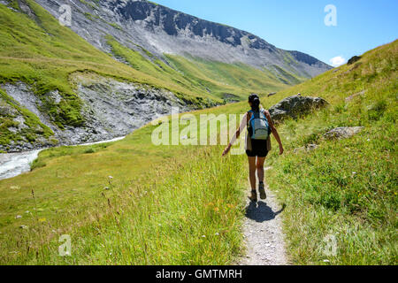 Woman touching the green grass in a Valley during summer, French Alps,  France, Europe. Stock Photo