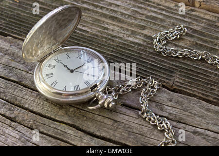 Old pocket watch with chain on wooden background Stock Photo
