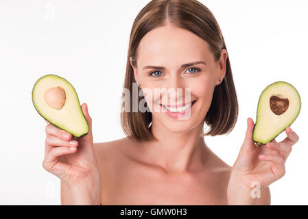 Cute young woman holding avocado Stock Photo