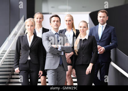 Portrait of business people standing on the steps of stairs Stock Photo