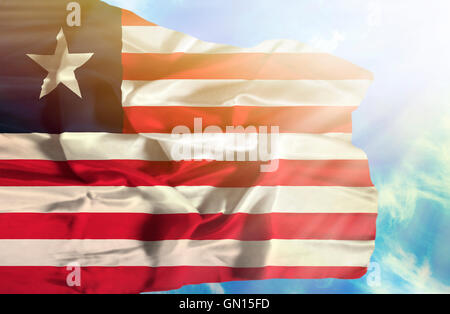 Liberia waving flag against blue sky with sunrays Stock Photo - Alamy