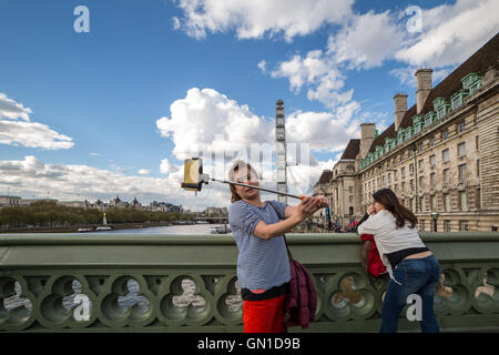 Tourists taking photos and phone selfies on Westminster bridge, London, UK. Stock Photo