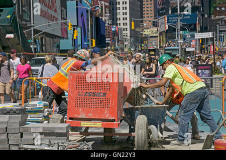 Construction workers mixing cement to repave streets in Times Square, Midtown Manhattan, New York City. Stock Photo