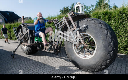 Rade, Germany. 27th Aug, 2016. Frank Dose for the first time on his built-bicycle, which he wants to set the Guinness Book record for 'the most heaviest wheeled bicycle in the world' in Rade, Germany, 27 August 2016. The vehicle currently weighs 940 kg on the scale but can potentially increase to around 1.2 tonnes. Photo: Markus Scholz/dpa/Alamy Live News Stock Photo