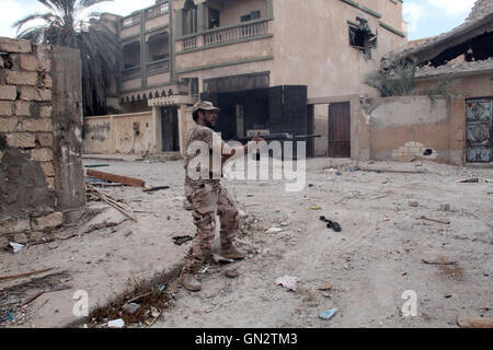 Sirte, Libya. 28th Aug, 2016. A member of the forces loyal to Libya's UN-backed Government of National Accord (GNA) takes an action targeting the Islamic State (IS) militants in the coastal city of Sirte, east of the capital Tripoli, Libya, on Aug. 28, 2016. Fierce clashes against the Islamic State (IS) militants in the Libyan city of Sirte killed 18 soldiers and injured another 120 on Sunday, according to Sirte's field hospital. Credit:  Hamza Turkia/Xinhua/Alamy Live News Stock Photo