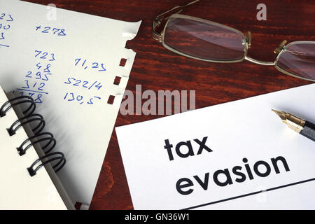 Tax evasion written on a paper. Financial concept. Stock Photo