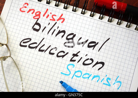 Sign bilingual education written in a notepad on a table. Stock Photo