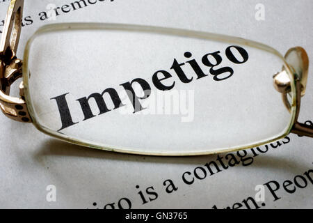 Paper with word Impetigo and glasses. Medical concept. Stock Photo