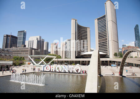 NathanPhillips Square in Toronto, Canada with new city hall, water fountain and the famous 'TORNONTO'  art sign Stock Photo