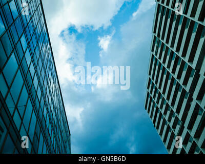 two buildings cover almost all the view of the sky, clouds are over me but a spot of  blue sky makes me hopeful Stock Photo