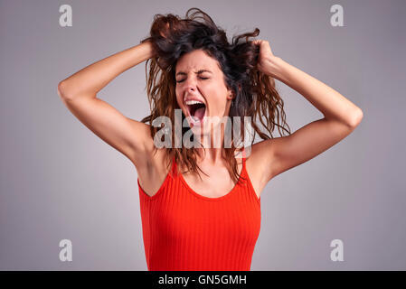 A beautiful young woman screaming furiously. Stock Photo