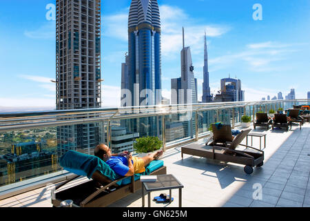 Businessman relaxing on the roof of hotel in Dubai, United Arab Emirates Stock Photo