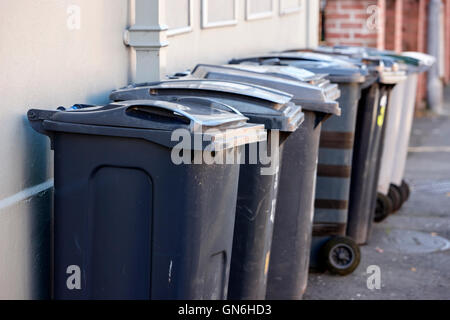 line of wheelie refuse bins left out on the pavement for collection Stock Photo