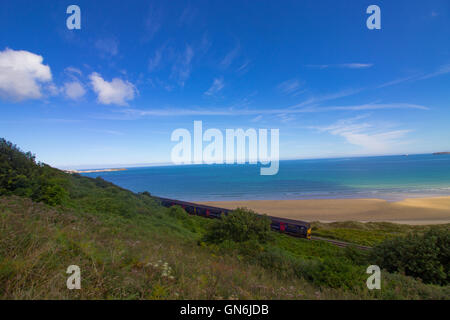 A train runs on the picturesque St Ives Bay Railway Line passing through Lelant Beach in the ...