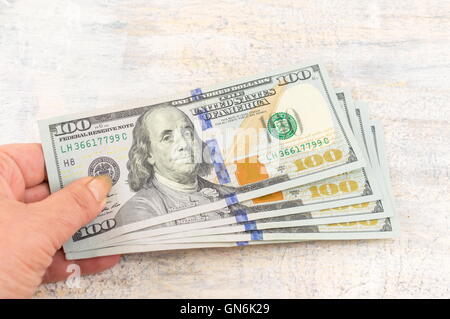 Female hands holding one hundred dollar bills Stock Photo