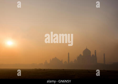 The rising sun in the early morning mist over the Taj Mahal in Agra, Uttar Pradesh. India Stock Photo