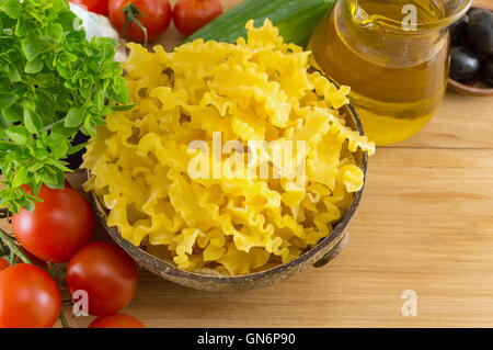 Bow tie farfalle pasta in a bowl with vegetables on the table Stock Photo