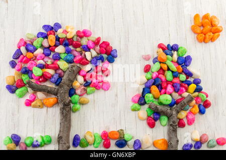Colorful rocks forming a tree shape on wooden table Stock Photo