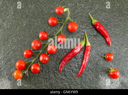 Raw tomato and red pepper on stone background Stock Photo