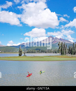 Kayakers on Sparks lake with Broken Top Peak in the background, in the Oregon Cascades near the city of Bend. Unreleased. Stock Photo