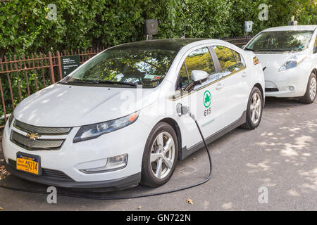 A New York City Parks department Chevy Volt electric car receives a charge at a charging station in Central Park. Stock Photo