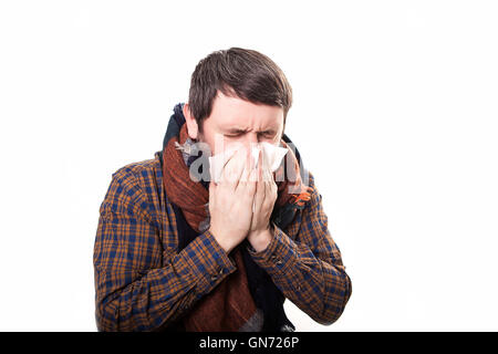 young sick and ill man in bed holding tissue cleaning snotty nose having temperature feeling bad infected by winter grippe virus in flu and influenza health care concept Stock Photo