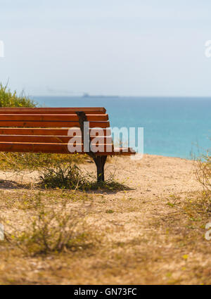wooden bench close-up on a sandy sea shore Stock Photo