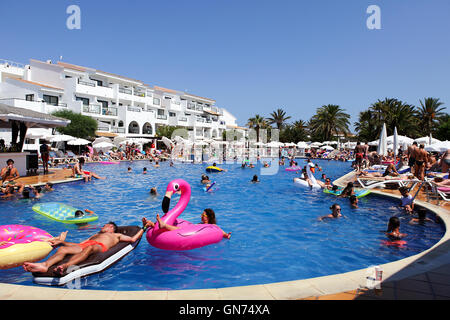 Families and holidaymakers enjoying the weather and the pool during summer holidays in Ibiza, Spain. Stock Photo
